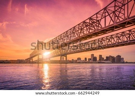 New Orleans, Louisiana, USA at Crescent City Connection Bridge over the Mississippi River during sunset.