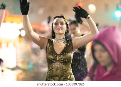 New Orleans, Louisiana, USA - February 23, 2019: Mardi Gras Parade, Women Dancing Under Heavy Rain At The Pardi Gras Parade, At Night