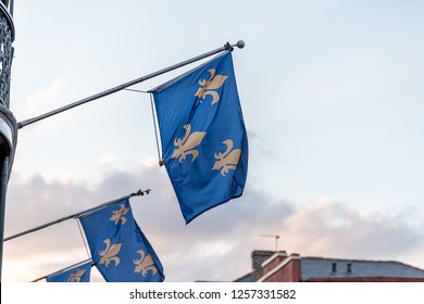 New Orleans old town street in Louisiana famous town, city, fleur-de-lis blue flags hanging off balcony wall, nobody at dark evening sunset, architecture, clouds in sky