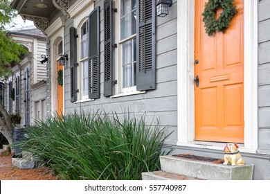 New Orleans quaint shotgun houses with gingerbread trim and front doors painted orange. Vintage architectural style seen in the city's historic neighborhoods, which are now trendy.