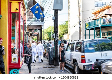New Orleans, USA - April 22, 2018: Frenchmen street in Louisiana old town city with people, sailors walking by bars, restaurants and pubs cafe