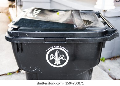 New Orleans, USA - April 22, 2018: Closeup of outdoor city trash can or rubbish garbage bin in Louisiana city with fleur-de-lis sign symbol outside