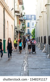 New Orleans, USA - April 23, 2018: Old Town Narrow Street In Louisiana City With Many People Walking On Sidewalk By Building Wall