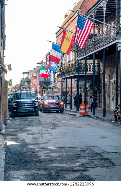 New Orleans, USA - Dec 4, 2017: Street scene along\
St. Ann Street in the iconic French Quarter; with flags and near\
Place d\'Armes Hotel. Brings back a sense of romantic nostalgia in\
this unique city.
