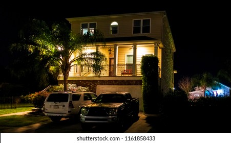 New Orleans, USA - Nov 27, 2017: Southern style American house along Fleur De Lis Drive, with lit up front porch. Night scene with Christmas lights on the side of the house.
