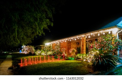 New Orleans, USA - Nov 27, 2017: Southern style American house along Fleur De Lis Drive, with lit up entrance. Night scene with Christmas lights at the front of the house.