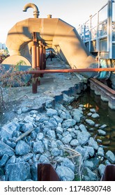 New Orleans, USA - Nov 28, 2017: View Of The 17th Street Canal Pump Station. Features Metal Pipe And Stone Rubble In Foreground. The Station Forms Part Of The City's Flood Control Mechanism.