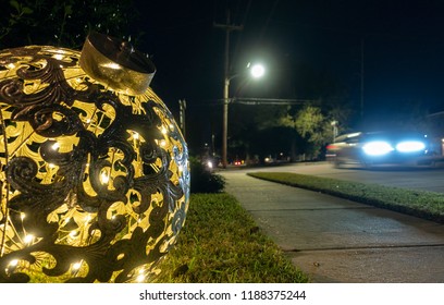 New Orleans, USA - Nov 29, 2017: A giant hollow Christmas tinsel sitting on outside lawn lit up along Fleur De Lis Drive. Night scene with a car driving by.