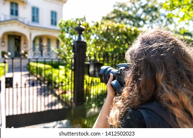 New Orleans, USA Old historic Garden district in Louisiana with green spring summer day and woman photographer taking picture of house with camera