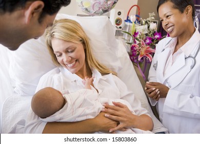 New Parents With Baby Talking To Doctor And Smiling