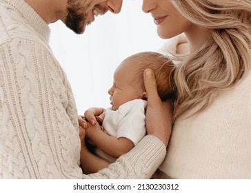 New Parents Smiling And Holding Their Newborn Baby Girl. 