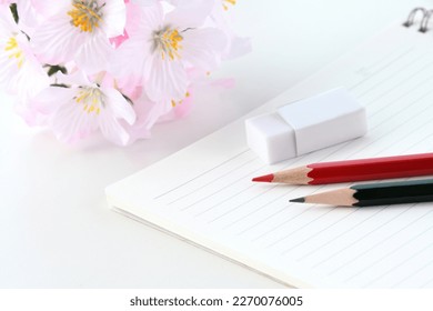 New pencils and eraser on notebook with artificial cherry blossoms - Shutterstock ID 2270076005