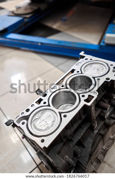 New pistons and\
cylinder head of engine block vehicle. Motor capital repair.\
Sixteen valve and four cylinder. Car service concept. The job of a\
mechanic. Old and new\
pistons.