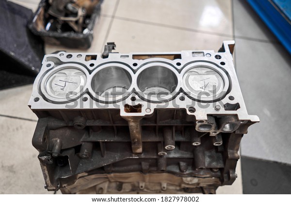 New pistons and\
cylinder head of engine block vehicle. Motor capital repair.\
Sixteen valve and four cylinder. Car service concept. The job of a\
mechanic. Old and new\
pistons.