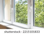 new plastic pvc window with white metal frame installed at modern house, view of blurred green trees. advertising concepts