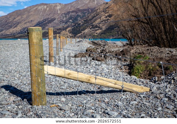 New\
post and netting fence dividing the farm boundary from the river\
bed  in the high country, Canterbury, New\
Zealand