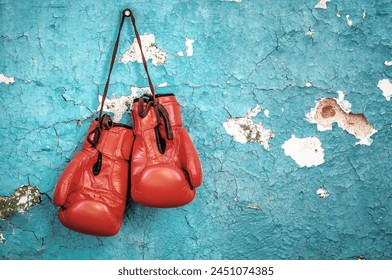 New professional red boxing gloves on the nail on old cracked wall - Powered by Shutterstock