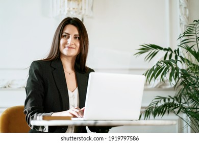 New project at work. The lawyer is sitting next to the laptop. Copy space. The Finance Manager Student beautiful brunette. A woman in a business suit. Works in a modern office.