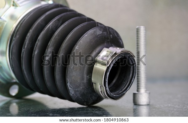 New protective cover for the drive shaft of a modern\
car on a steel background. The part prevents dirt and dust from\
getting into the drive shaft and keeps the part working. Car\
service and spare part