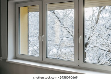 New pvc window frame with high thermal insulation values. Concepts of safe, warm and quiet home. Living room or bedroom with view at natural parkland at winter - Powered by Shutterstock