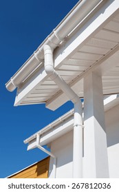 New Rain Gutter On A White Home Against Blue Sky