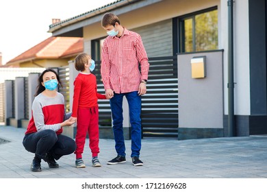 New Real Life. Fight Coronavirus. Young Family Wearing Face Mask Outdoors. Safety Mask To Protect Coronavirus Outbreak. Prevention Coronavirus. Son With Parents Going For A Walk.