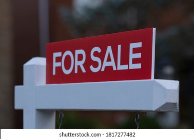 New Red Sign For Sale In Front Of House In Residential Area. Real Estate Bubble, Bidding War, Hot Housing Market, Overpriced Property, Buyer Activity, Spring And Summer Sale  Concept. Selective Focus.