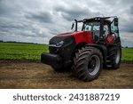 new, red tractor near a field of young beets, agriculture, preparation for the season