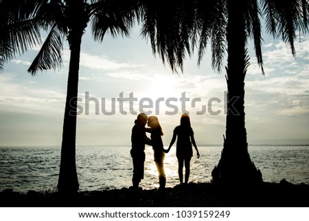 New relationship concept. Love triangle. Young man falls in love with another woman Silhouette on the seashore.