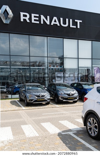 New Renault cars are parked outside Renault\
dealership. On facade of building there is inscription Renault with\
logo. Renault car dealership in Mega Adygea. Krasnodar, Russia -\
August 17, 2021