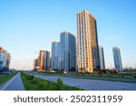 New residential buildings in residential complex. Bicycle path, pedestrian road in city. High multi-storey buildings. Modern apartment buildings. Colorful multi-story buildings on sunset. Housing