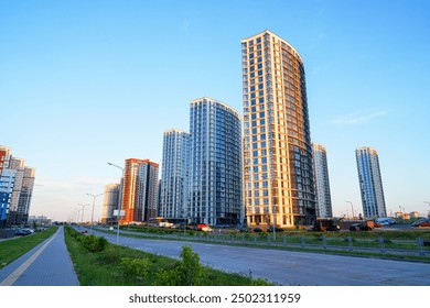 New residential buildings in residential complex. Bicycle path, pedestrian road in city. High multi-storey buildings. Modern apartment buildings. Colorful multi-story buildings on sunset. Housing - Powered by Shutterstock