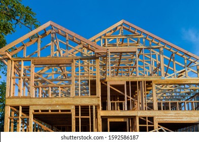 New residential construction home framing home against a blue sky