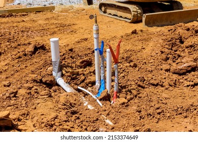 New Residential Construction Home With Laying Sewer Pipes And Water Pipe In The Ground Under The Foundation