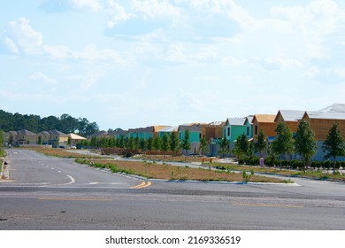 New Residential Neighborhood Under Construction With Half Built Cynder Block And Wood Frame Homes, And Newly Planted Trees In South Florida To Address A Housing Shortage  On A Sunny Afternoon.