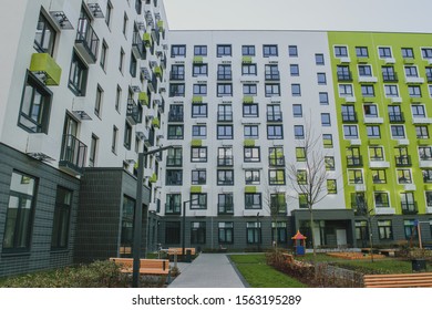 new residential quarter of new buildings: a modern playground in the courtyard of an apartment building with a bright facade - Powered by Shutterstock