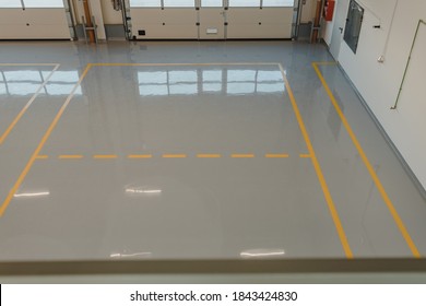 New  resin floor coating and marking signs in a car workshop.