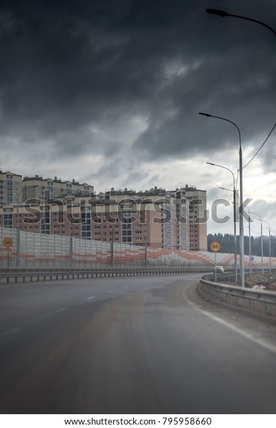 new\
road with acoustical barrier or a sound wall. Reducing of noise and\
sound pollution made by transportation. asphalt way to the new\
district with block of flats and apartment\
buildings.