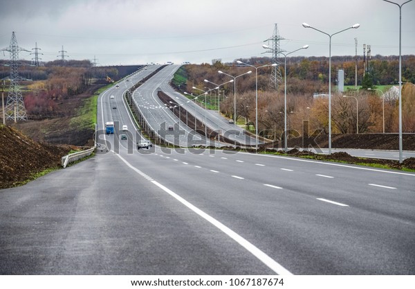 A new road with a dividing strip and\
lighting poles. Road\
construction.