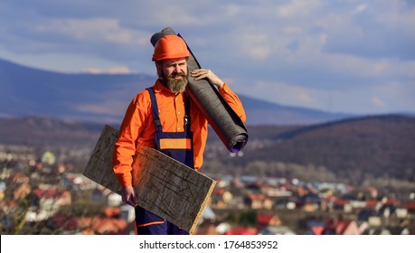 New Roof Under Construction Residential Building. Builder Use Roofing Felt. Professional Master Repair Roof. Flat Roof Installation. Roofer Worker In Special Protective Work Wear.