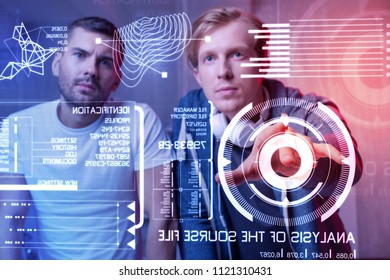 New security system. Smart creative web developers making a futuristic security system and testing it while sitting together in front of a transparent device