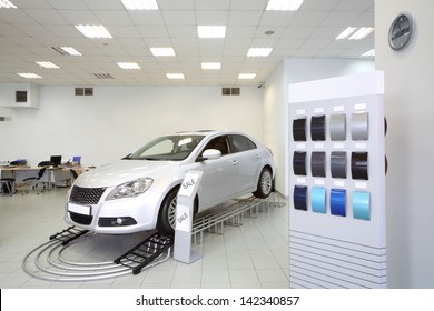 New Shine Car Stands In Office Of Shop Selling Cars Near Stand With Samples Of Paint For Body.