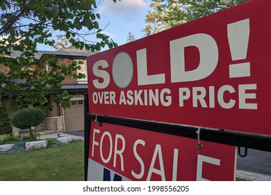 New Sign Sold Over Asking Price For Sale In Front Of Detached House In Residential Area. Real Estate Bubble, Crash, Hot Housing Market, Overpriced Property, Buyer Activity Concept. Selective Focus.