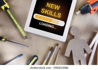 New Skills Loading On Digital Computer Tablet And Tools Supplies On Wooden Background. Reskilling And Upskilling Concept And Technology Transformation Learning Model Idea
