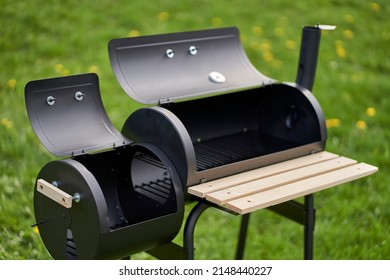 New smoker barbecue grill. Equipment for cooking and smoking. Opened burning and smoking chamber.