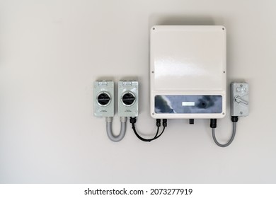 New solar panel inverter with isolators attached to the wall - Shutterstock ID 2073277919