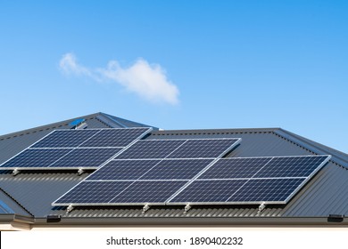 New Solar Panels Installed On Metal Sheet Roof Of The House In South Australia Against Clear Blue Sky With Small Cloud