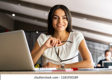 New Solution Every Day. Confident Young Woman In Smart Casual Wear Working On Laptop While Sitting At Her Working Place In Office