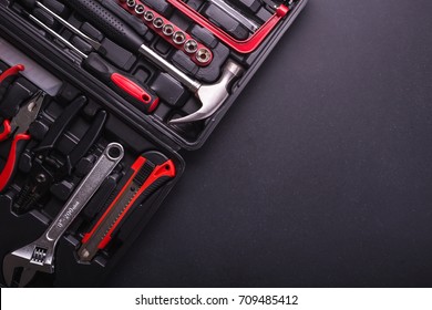 New square black tool box on black granite board background. Composition with free space for text or design. Top view