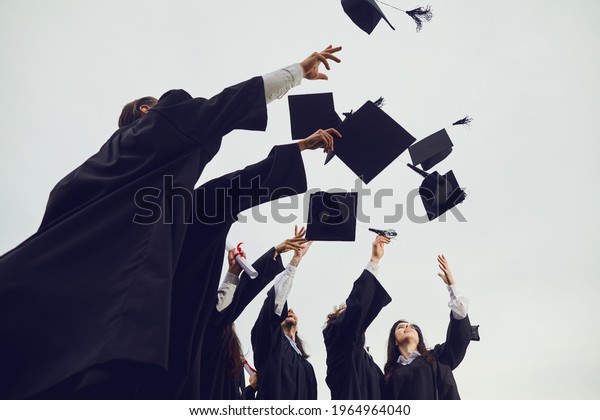 New stage of life. Graduates toss their academic
hats into the sky during a solemn ceremony at the university.
Students make a gesture of successful graduation. Education,
graduation and alumni.